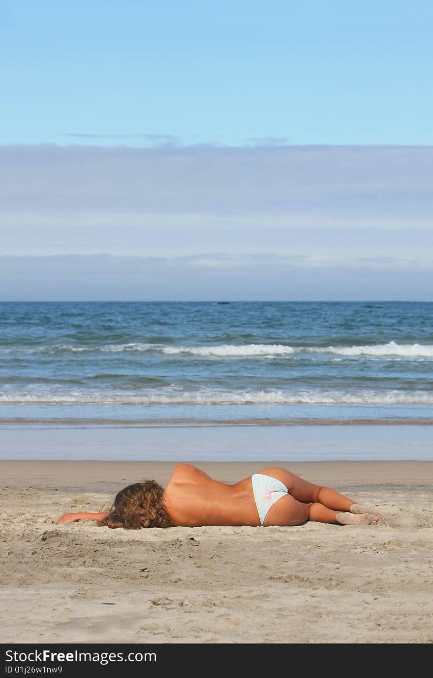 Beautiful woman lays on beach