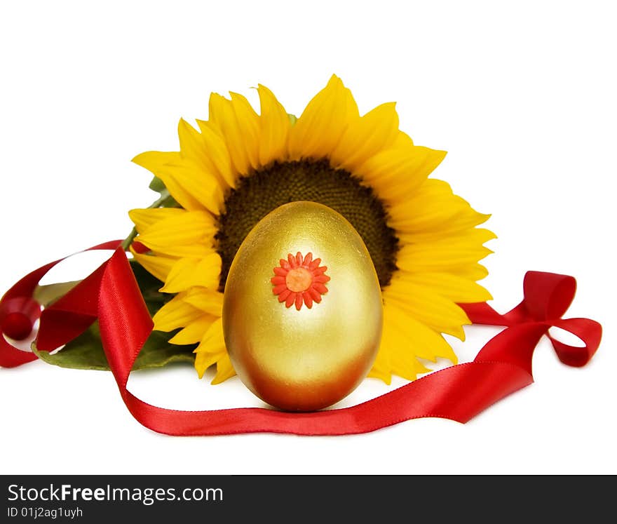 Celebration of Easter with golden decorated egg, sunflower and festive red ribbons. Isolated over white with clipping path. Celebration of Easter with golden decorated egg, sunflower and festive red ribbons. Isolated over white with clipping path.
