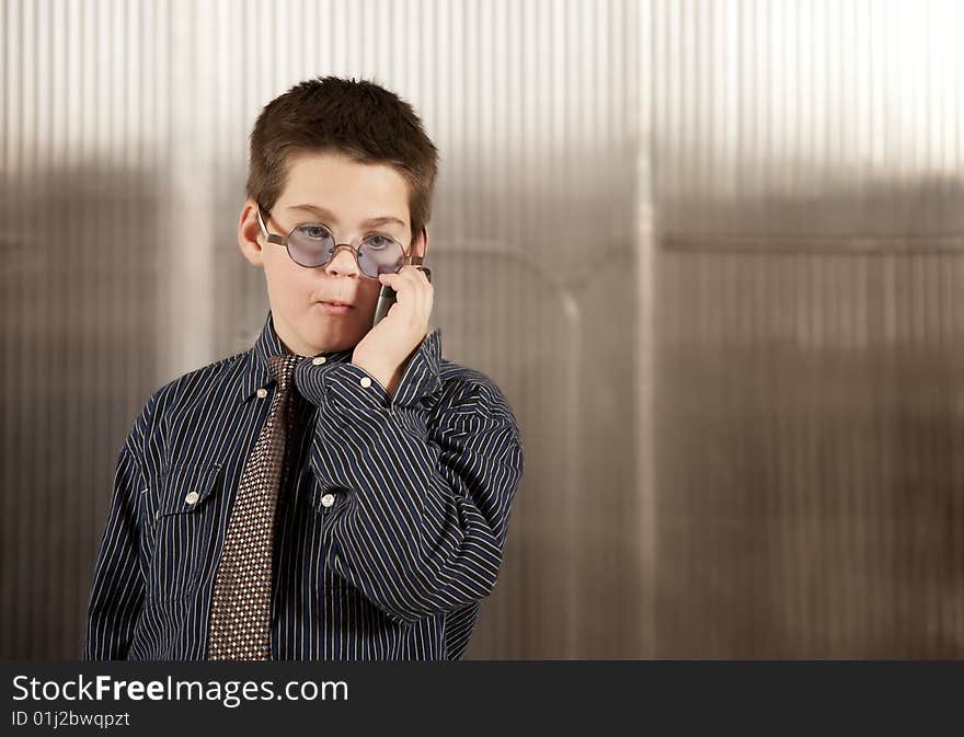 Little boy in adult clothes on cell phone