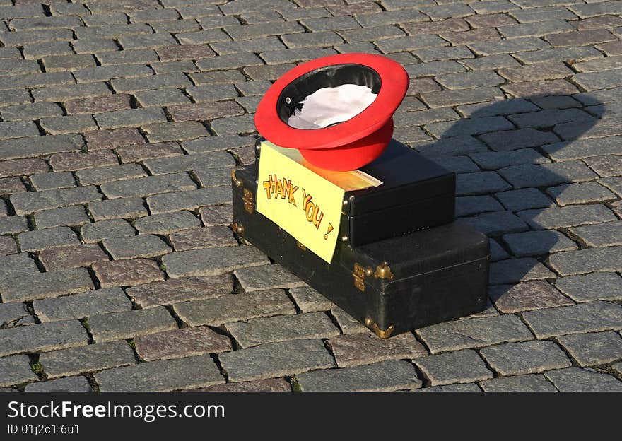 Asking for a contribution. Upturned hat on a musical instrument box with a sign saying Thank You. Asking for a contribution. Upturned hat on a musical instrument box with a sign saying Thank You