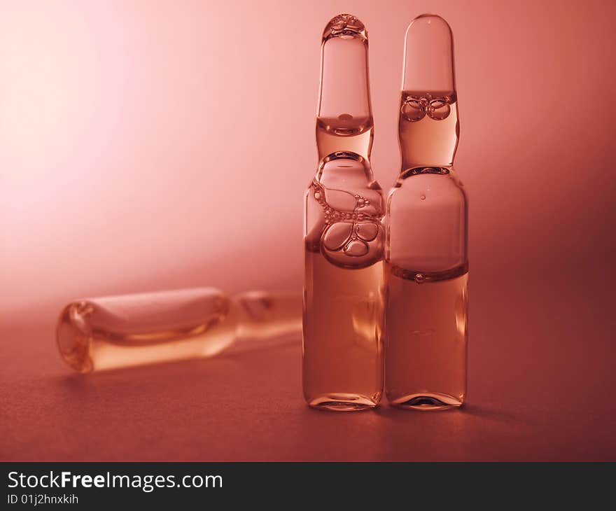 Colored vials on the red orange background