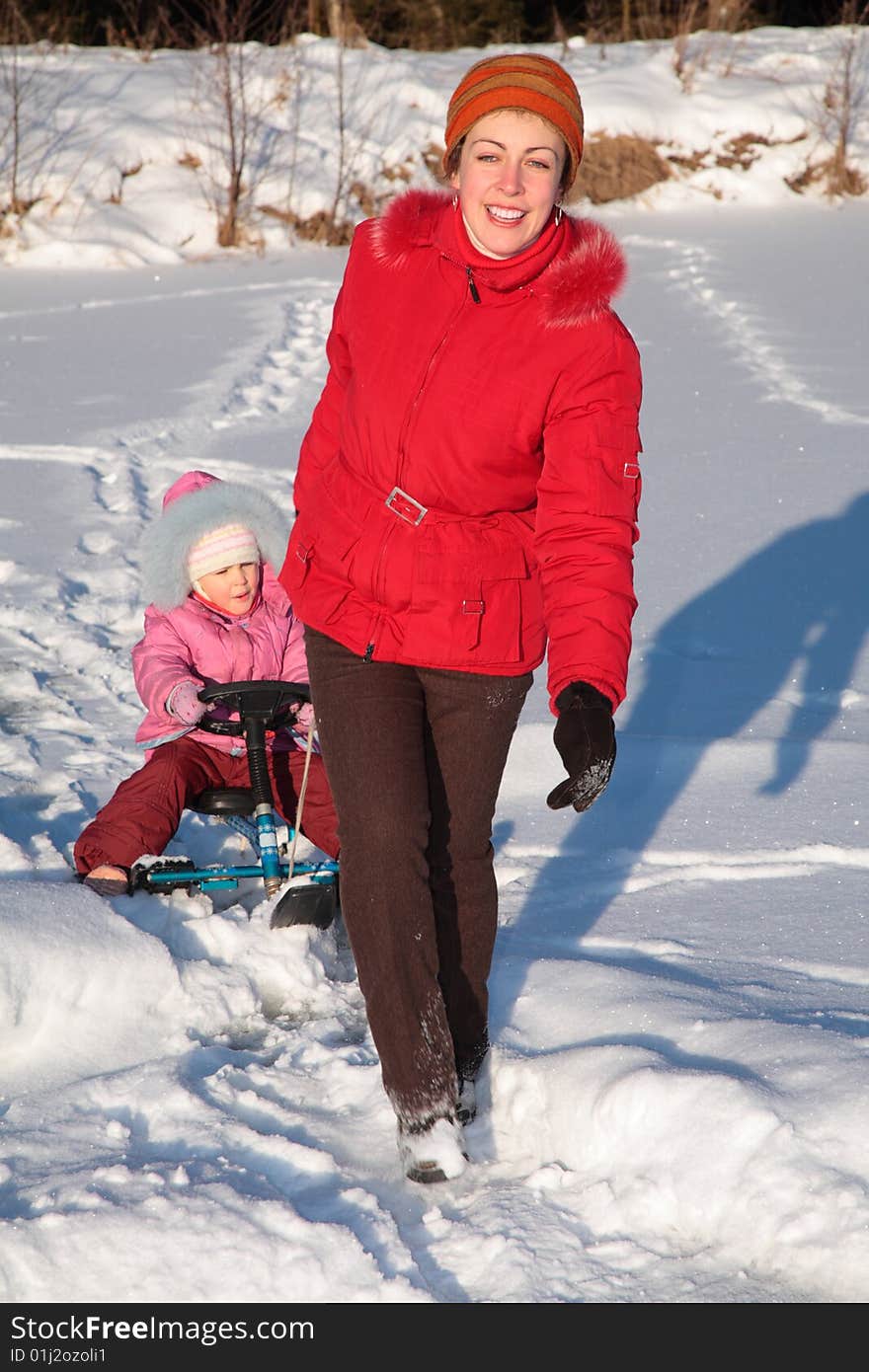 Mother Pulls Daughter On Snow Scooter