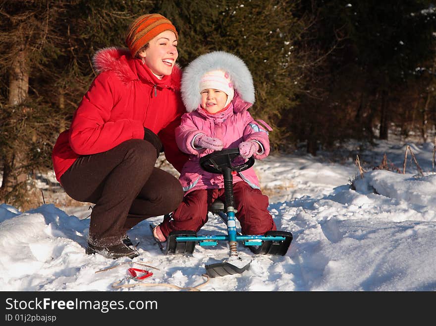 Mother and daughter with snow scooter