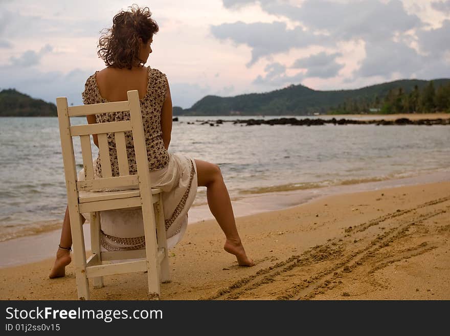 Woman to sit on the chair at sunset. Woman to sit on the chair at sunset