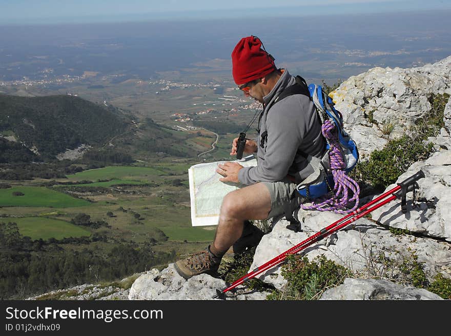 A handsome middle age hispanic latin man in a top of a in mountain hiking with a backpack looking the field with a googles. A handsome middle age hispanic latin man in a top of a in mountain hiking with a backpack looking the field with a googles