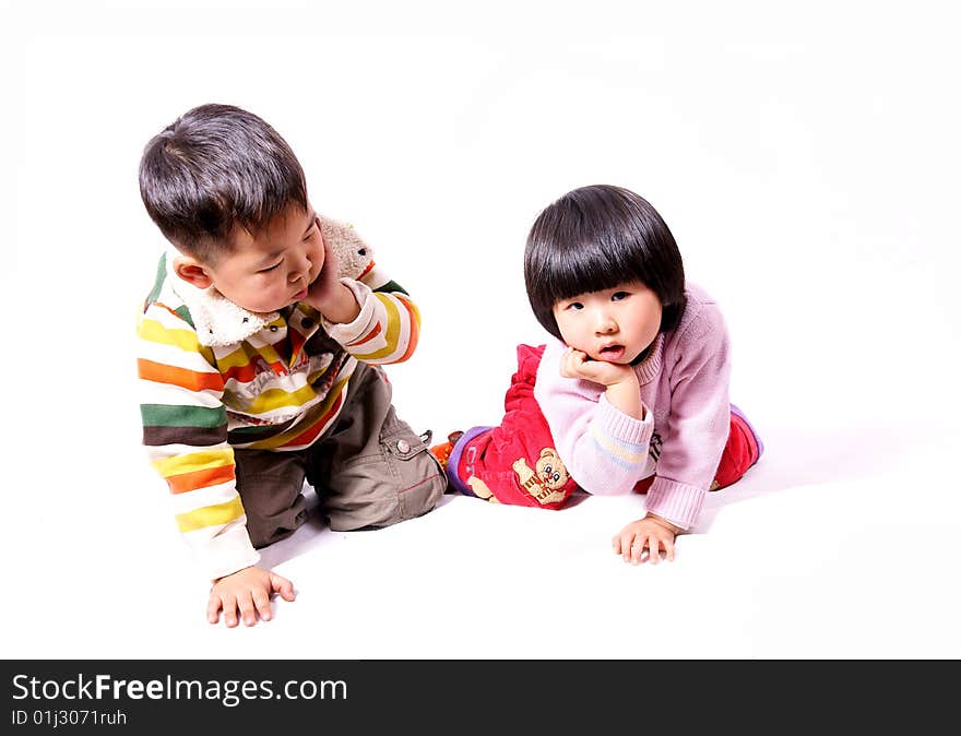 A picture of a little chinese boy and girl playing together with hand supporting chin