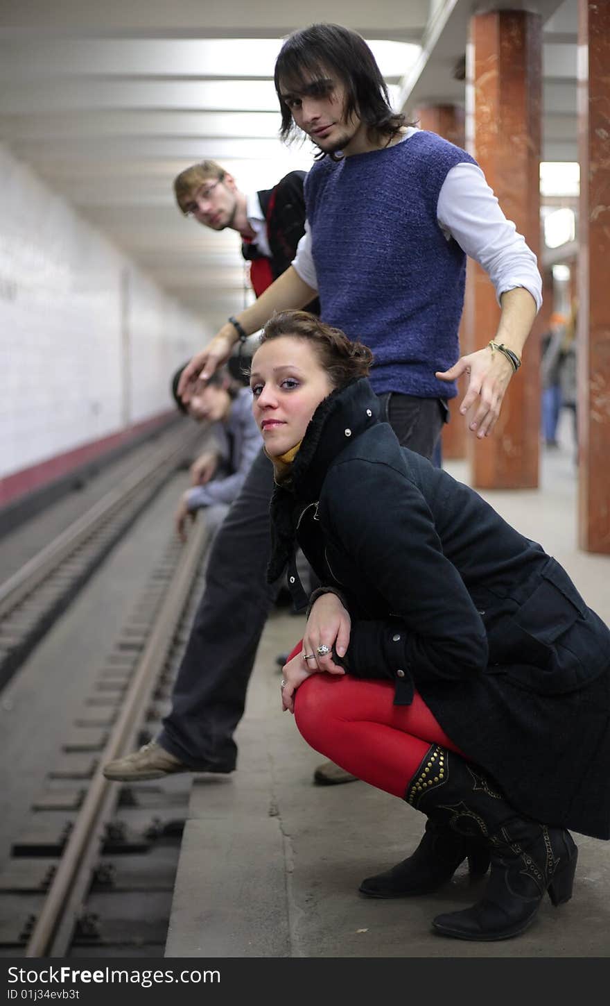 Group of young friends on edge on subway station