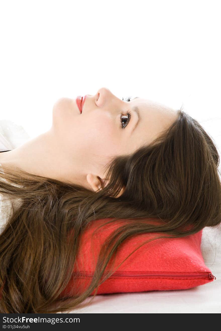 Young woman on red pillow isolated on white background