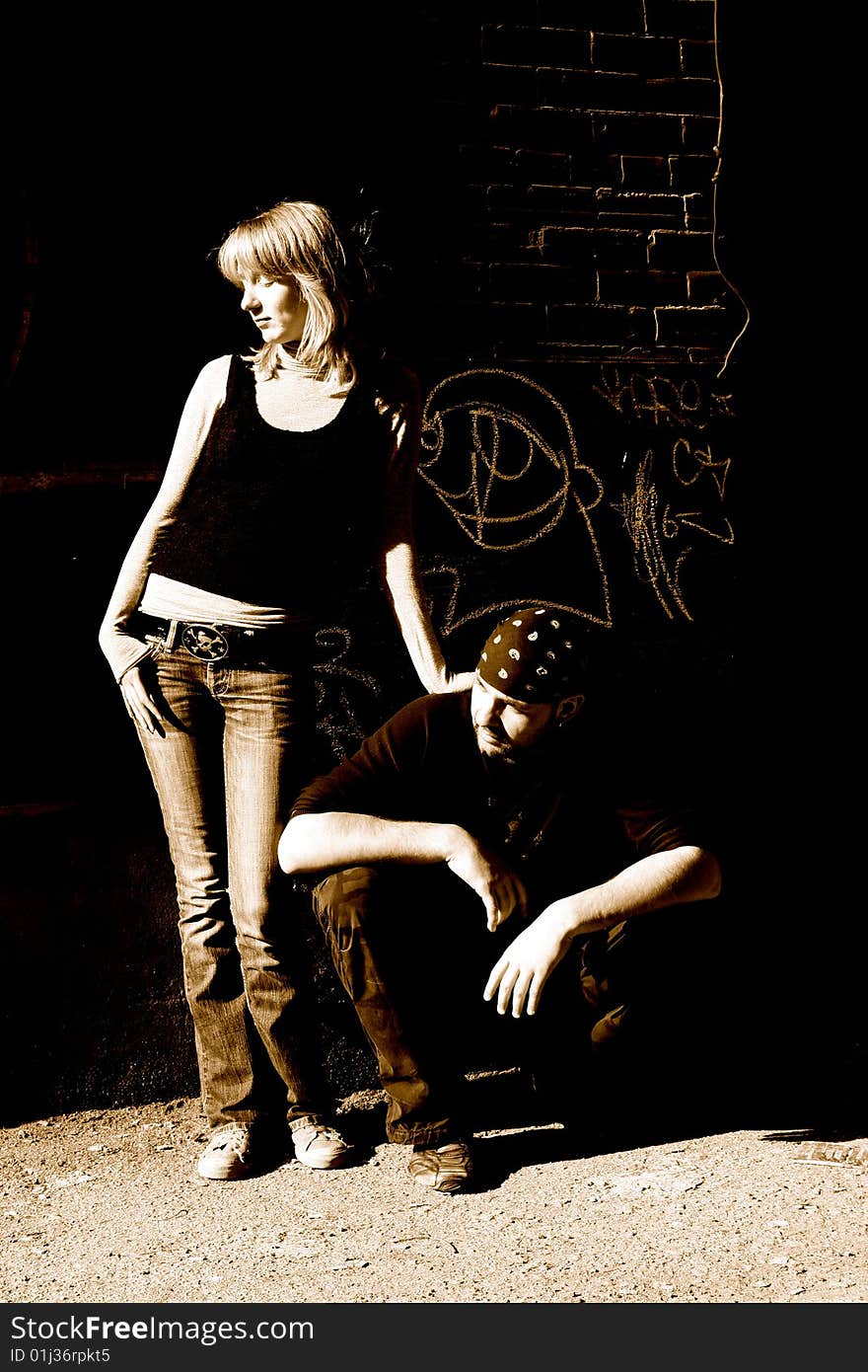 Young couple leaning against an old brick wall. Young couple leaning against an old brick wall