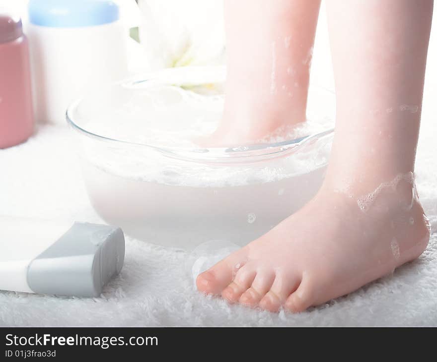 The child the boy washes the legs in soap water. The child the boy washes the legs in soap water