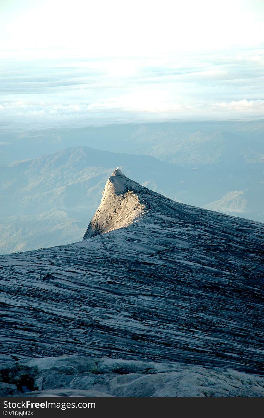 Sunrise over a mountiain range in Borneo, the tip of the mountain is in the sun. Sunrise over a mountiain range in Borneo, the tip of the mountain is in the sun.