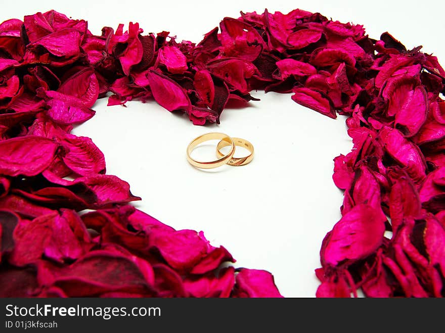 Wedding rings in red rose petals background