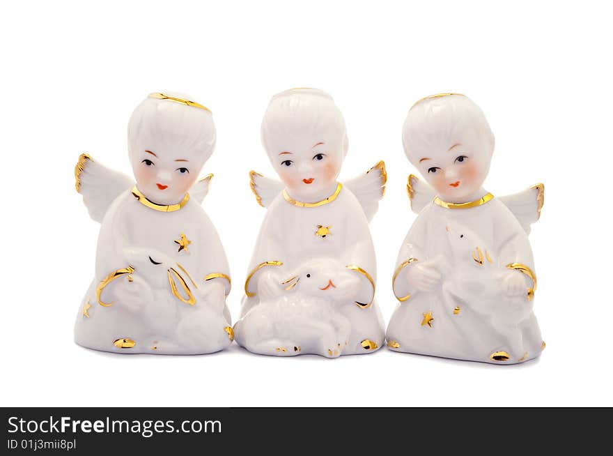 Three porcelain angels with rabbit, lamb and piglet. Isolated on white.