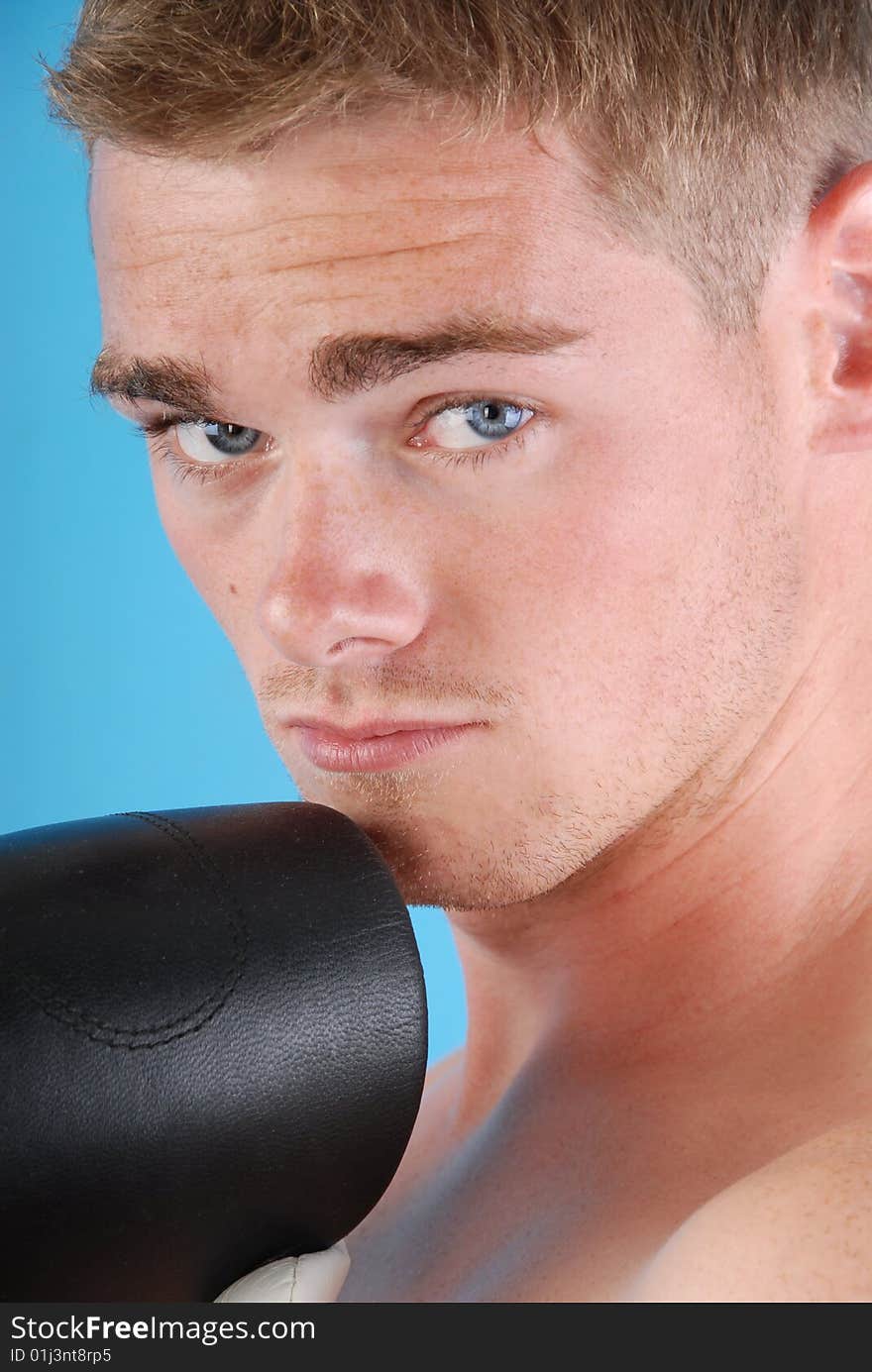 Young adult with boxing gloves against blue background. Young adult with boxing gloves against blue background