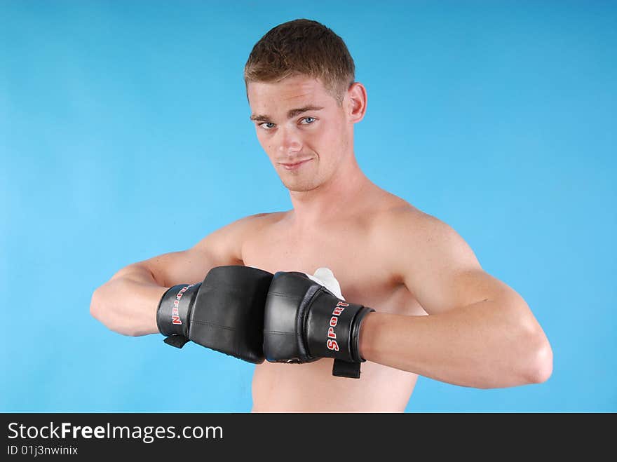 Young adult with boxing gloves against blue background. Young adult with boxing gloves against blue background