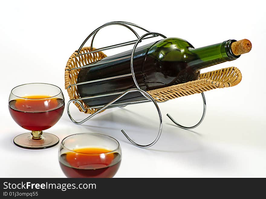 Wine bottle in basket and two glasses