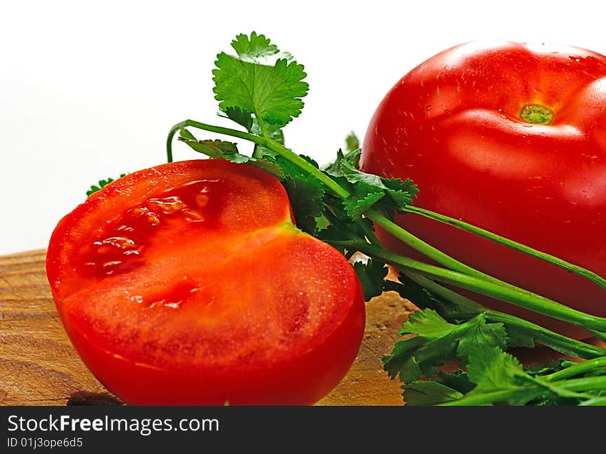 Tomato and coriander on a wooden plate