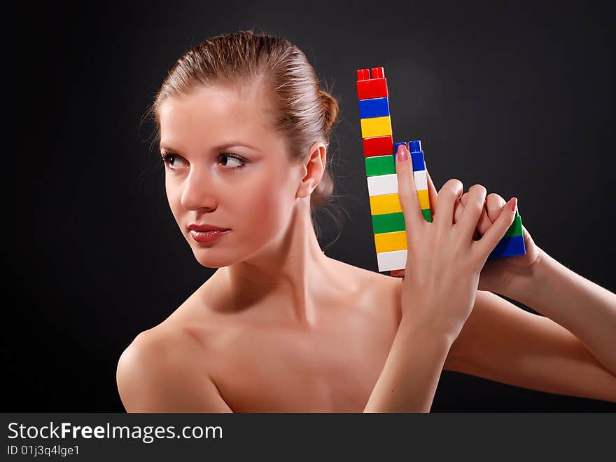 Portrait of young beautiful woman with toy gun