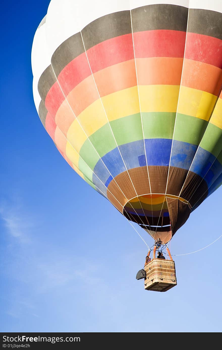 Unrecognizable people traveling in a multicolor balloon. Unrecognizable people traveling in a multicolor balloon