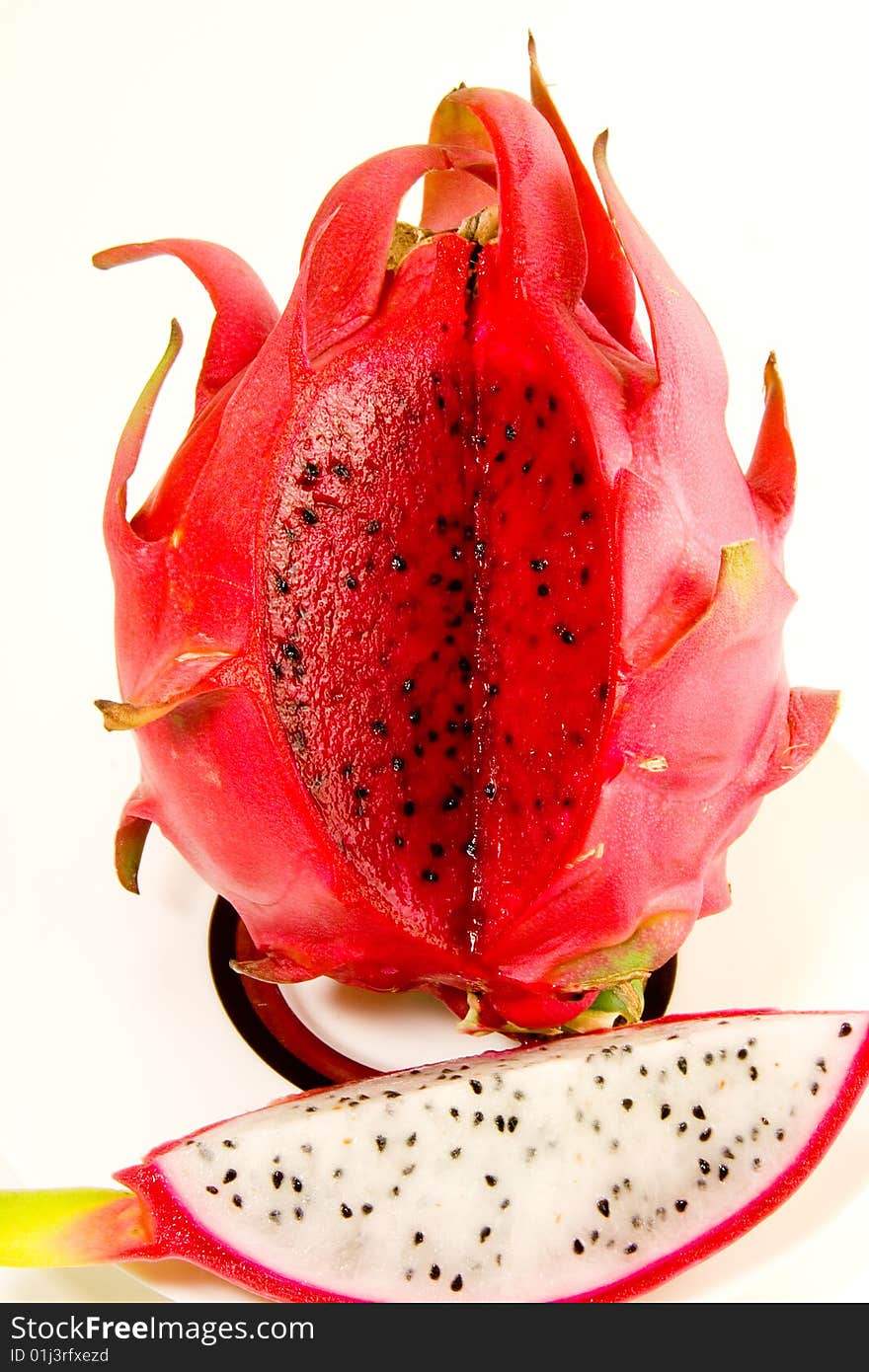 An exposed red Dragon fruit contrasted to a white one