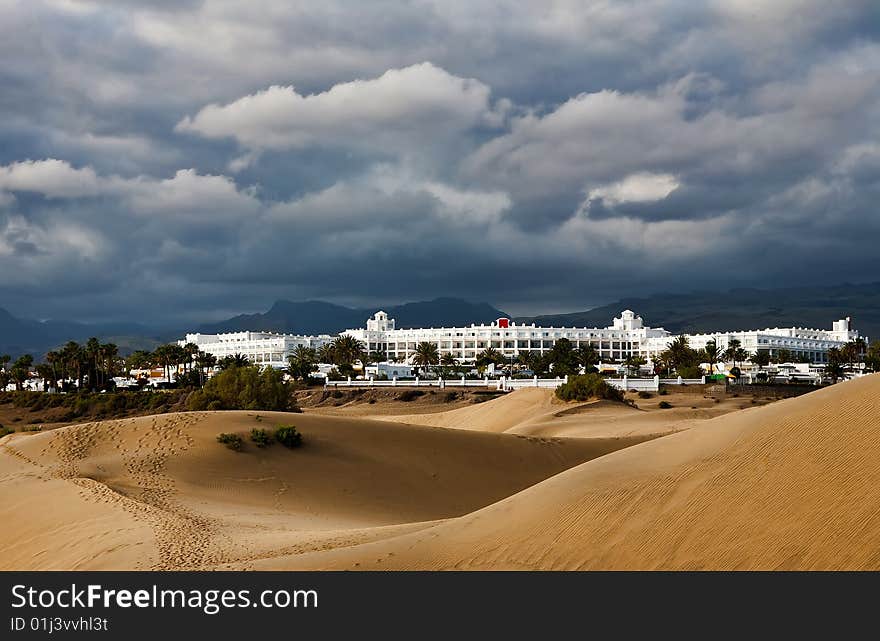 Beautiful resort beach near the desert dunes under dramatic cluods. Beautiful resort beach near the desert dunes under dramatic cluods