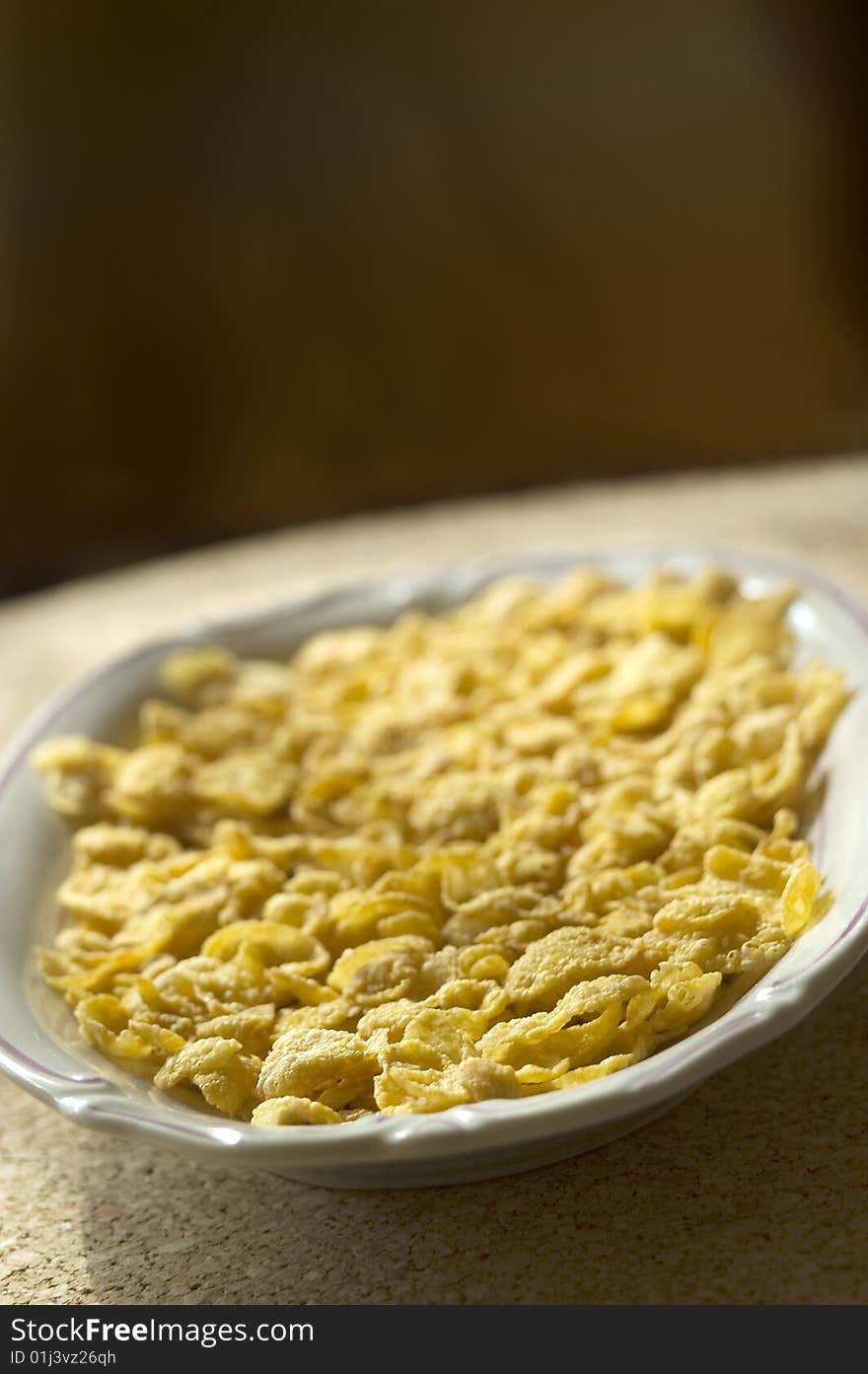 Dish full of corn flakes in the morning light. Dish full of corn flakes in the morning light