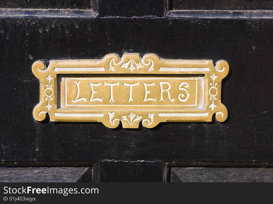 Old brass letterbox with the word letters engraved on it