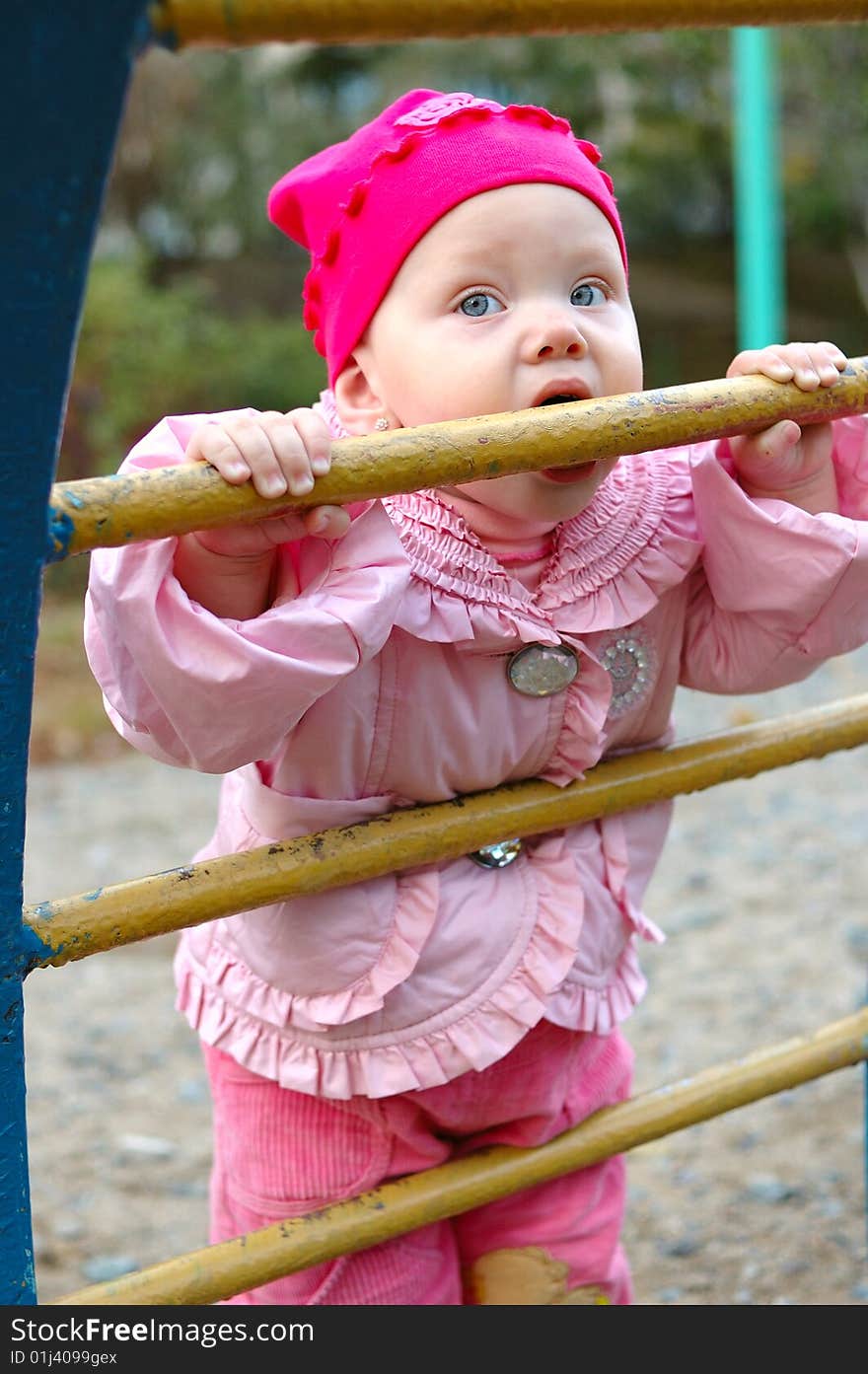 Pretty little girl on child's playground - outdoor portrait. Pretty little girl on child's playground - outdoor portrait.