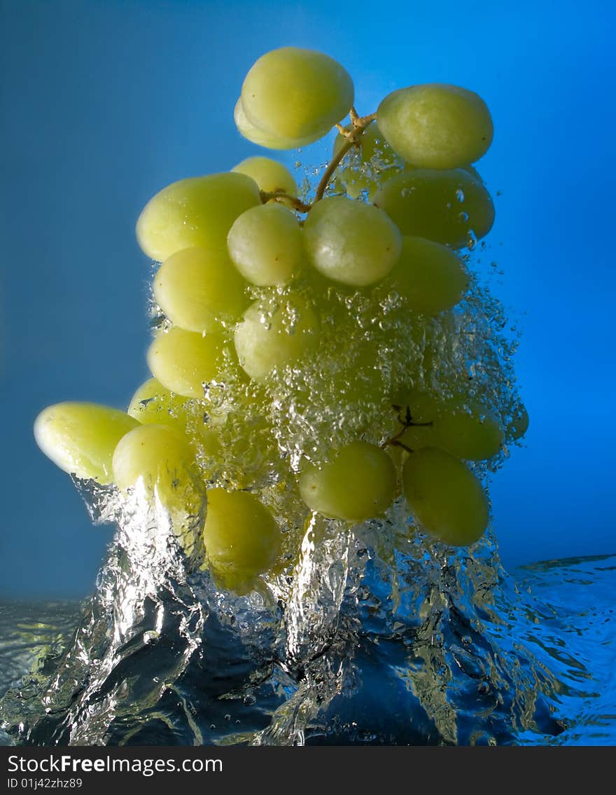 Grapes in water on a blue background