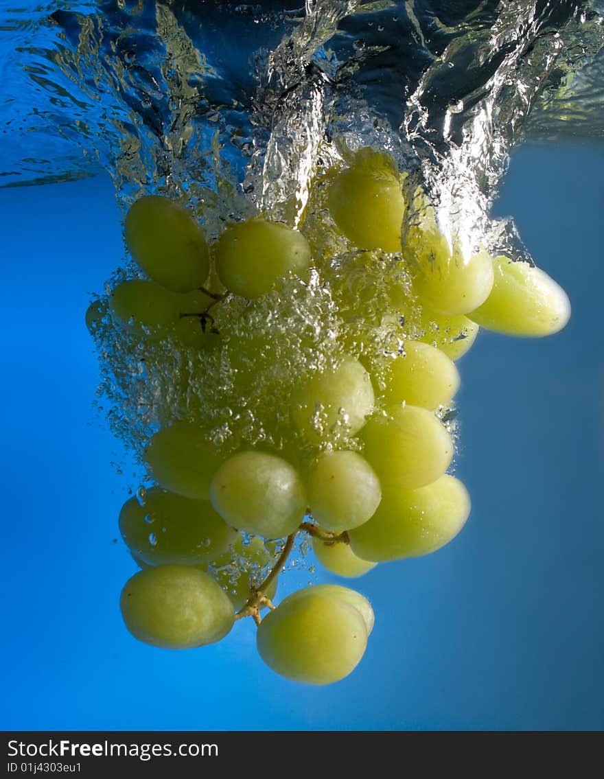 Grapes in water on a blue background