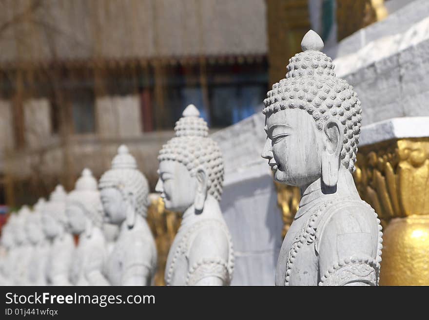 Stone buddha statue near by white pagoda