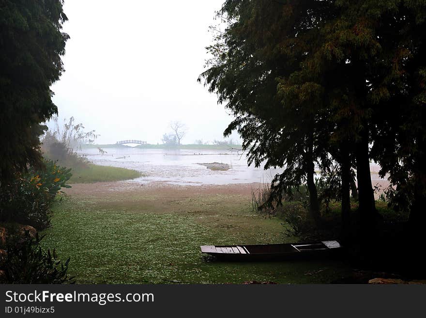 An old boat on the lake  in a rainy day