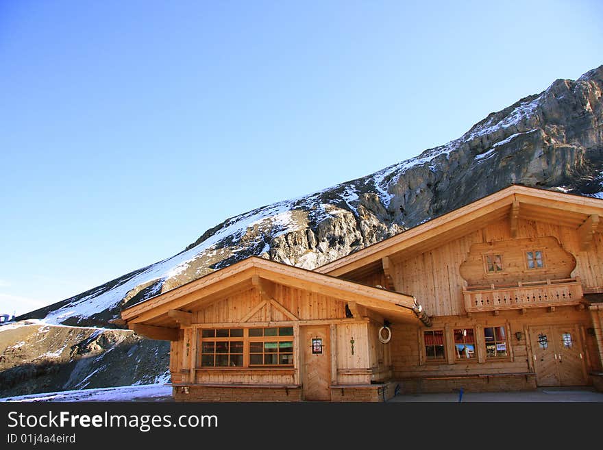 The view of swiss alps.Log cabins stand besides moutain.