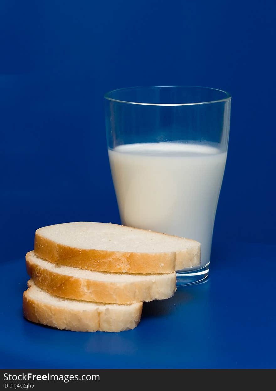 A glass of milk and toastes on a blue background. A glass of milk and toastes on a blue background