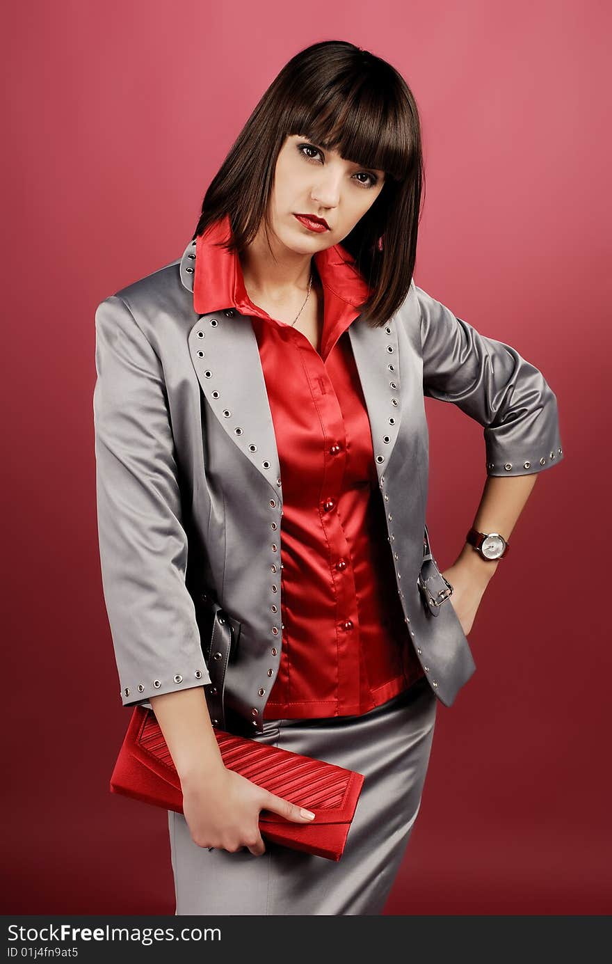 Model in studio on red background wearing business clothes. Model in studio on red background wearing business clothes.