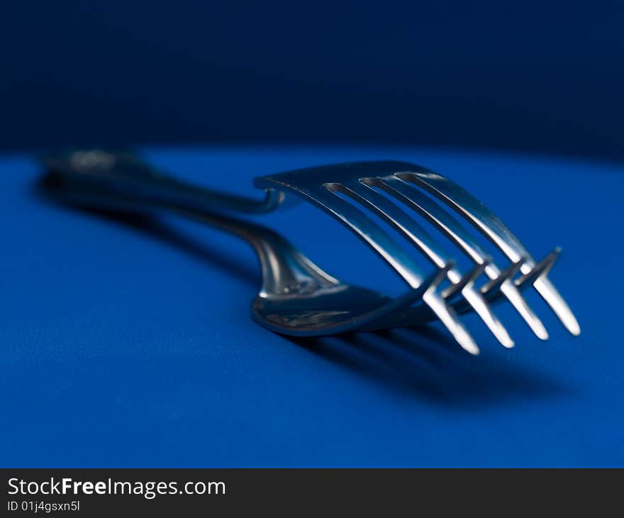 Forks crossing teeth on blue background. Forks crossing teeth on blue background