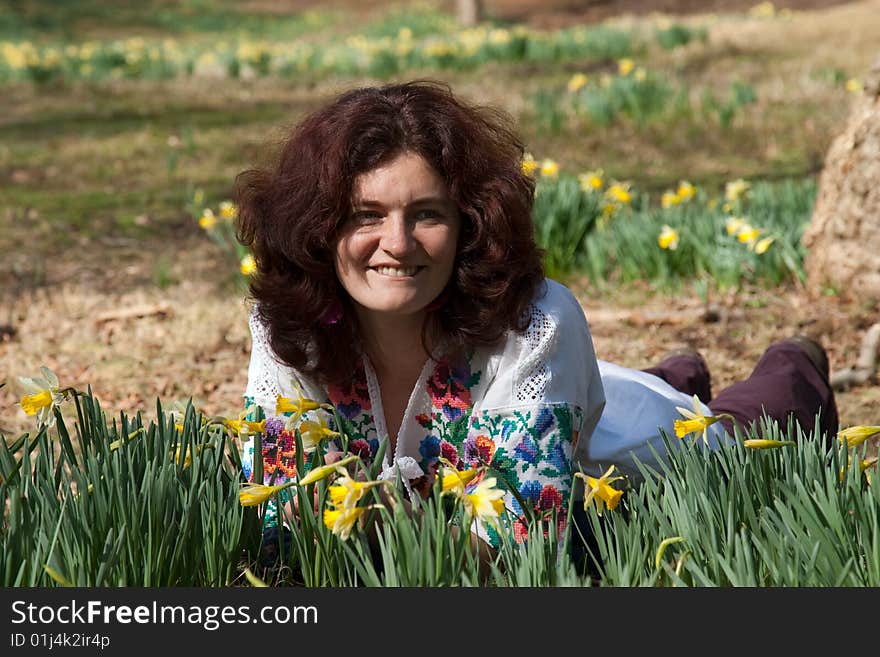 Smiling girl lie on a meadow with flowering daffodil. Smiling girl lie on a meadow with flowering daffodil