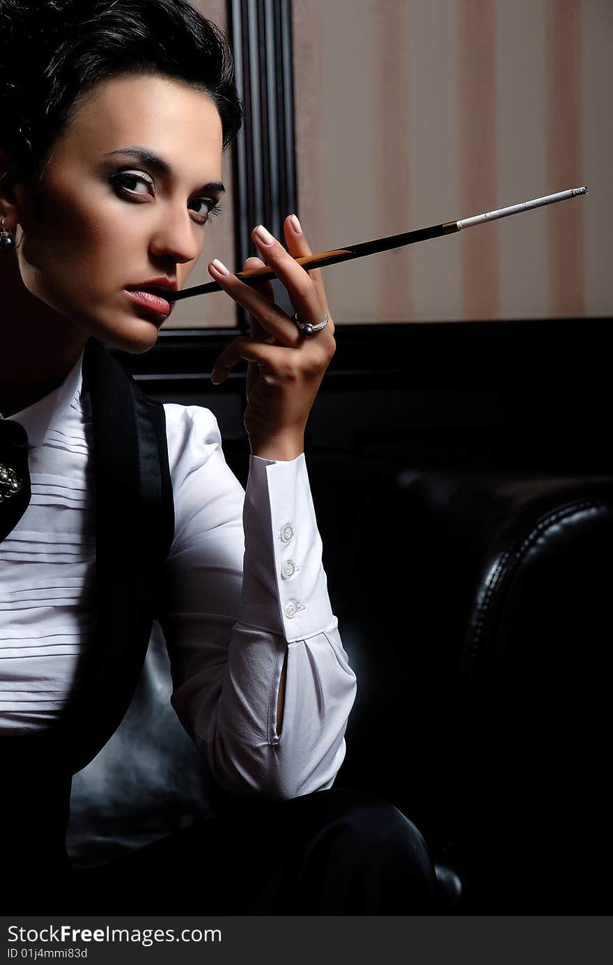 Woman on the striped background wearing business clothes, smoking. Woman on the striped background wearing business clothes, smoking.