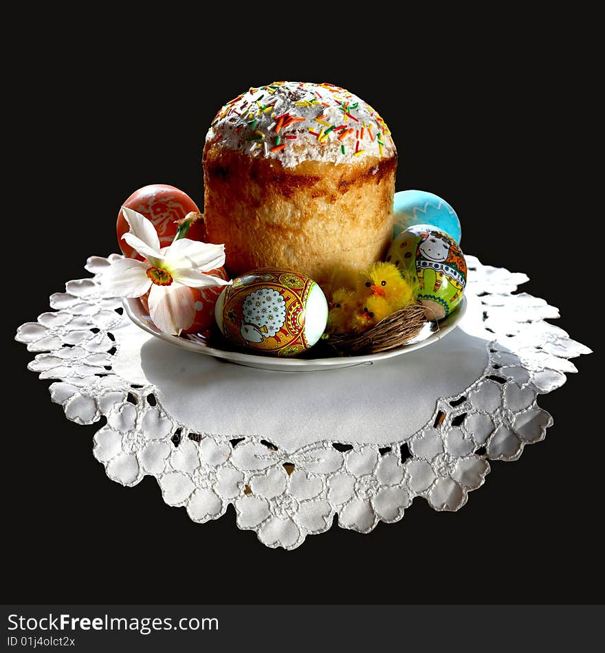 An image of an easter cake on a plate with eggs and flower