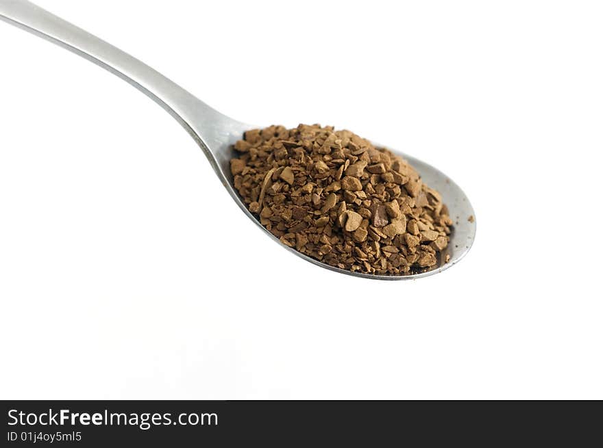 A spoon with instant coffee on white, macro