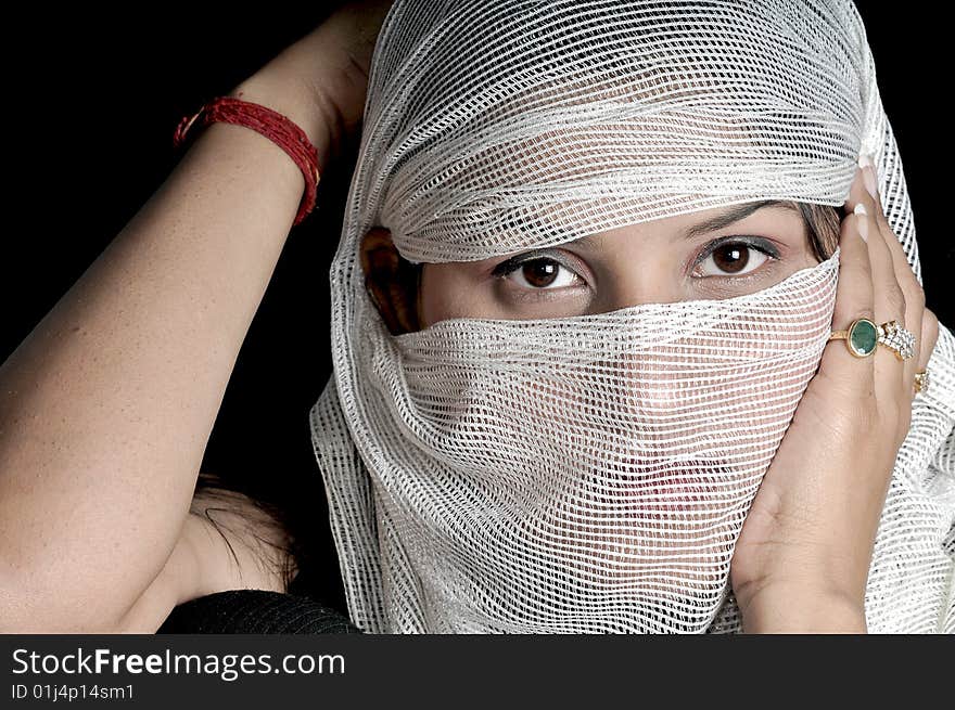 arabian girl posing while hiding her face in studio