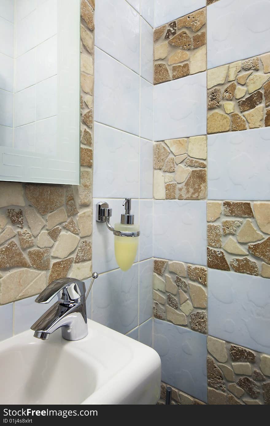 White sink and the metal tap in a bathroom