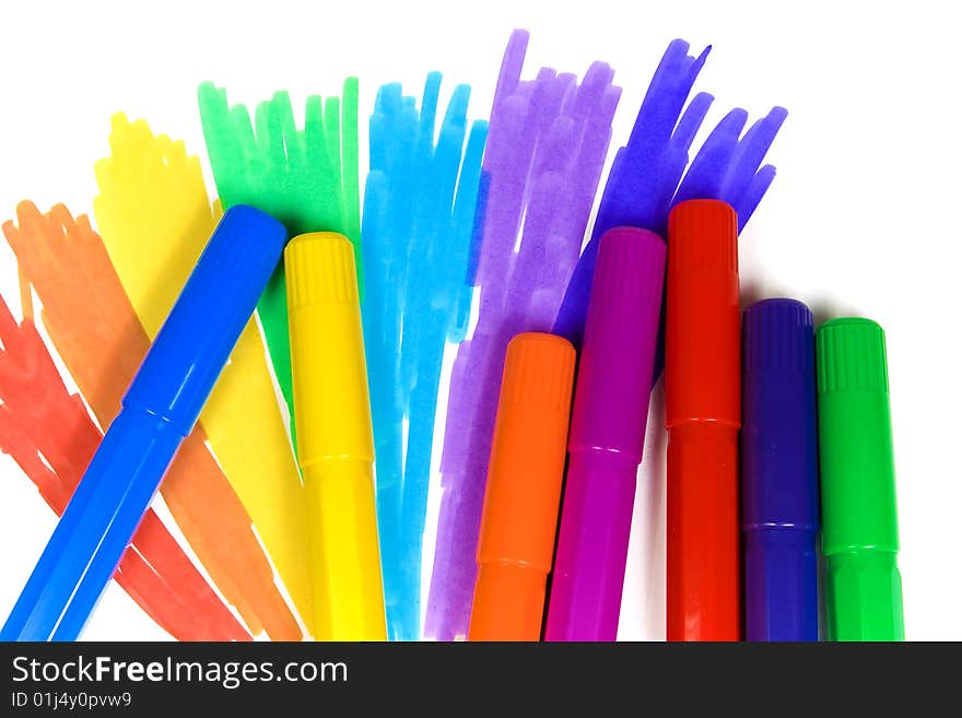 Seven felt-tip pens on a background of the drawn rainbow