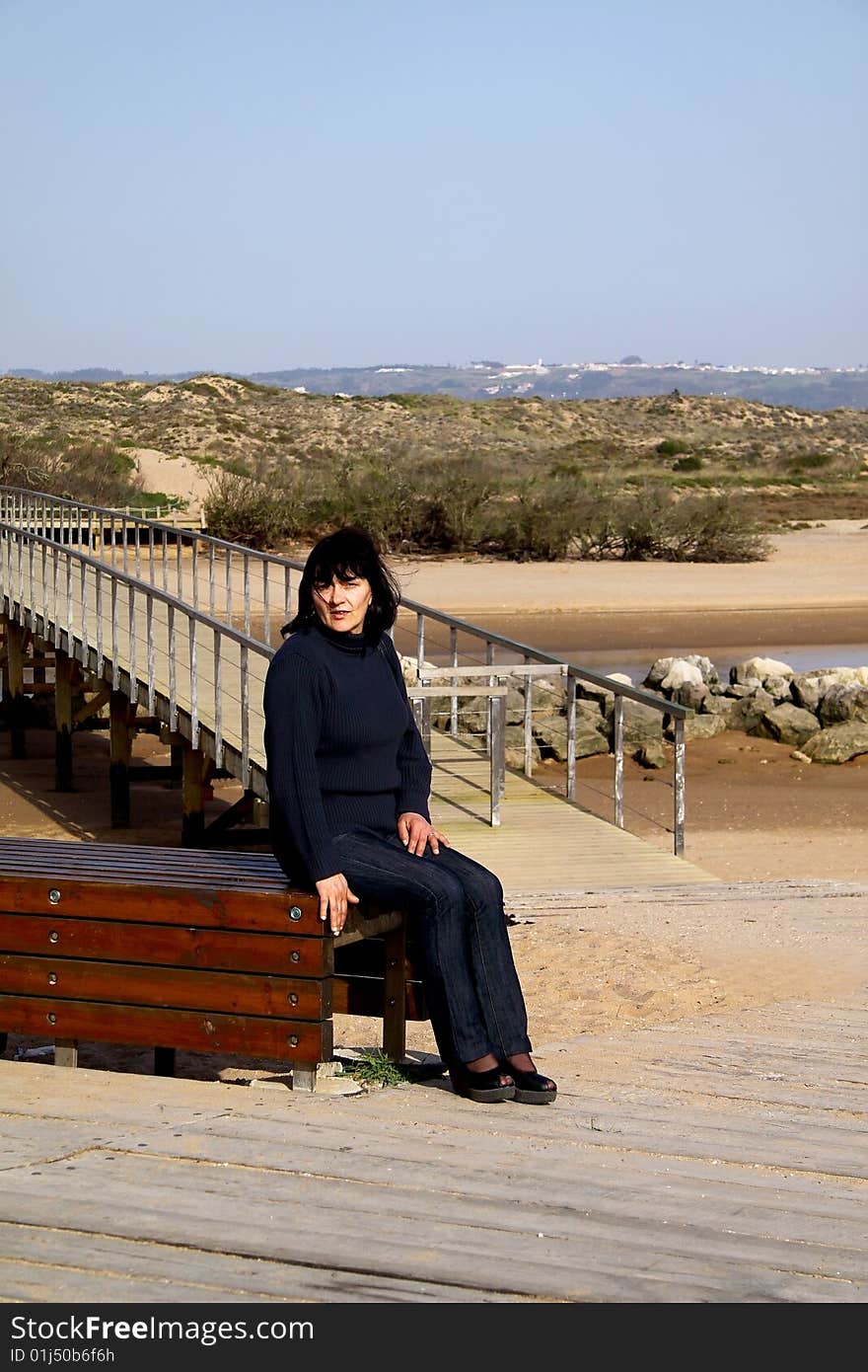 Woman Sitting Next To A Bridge