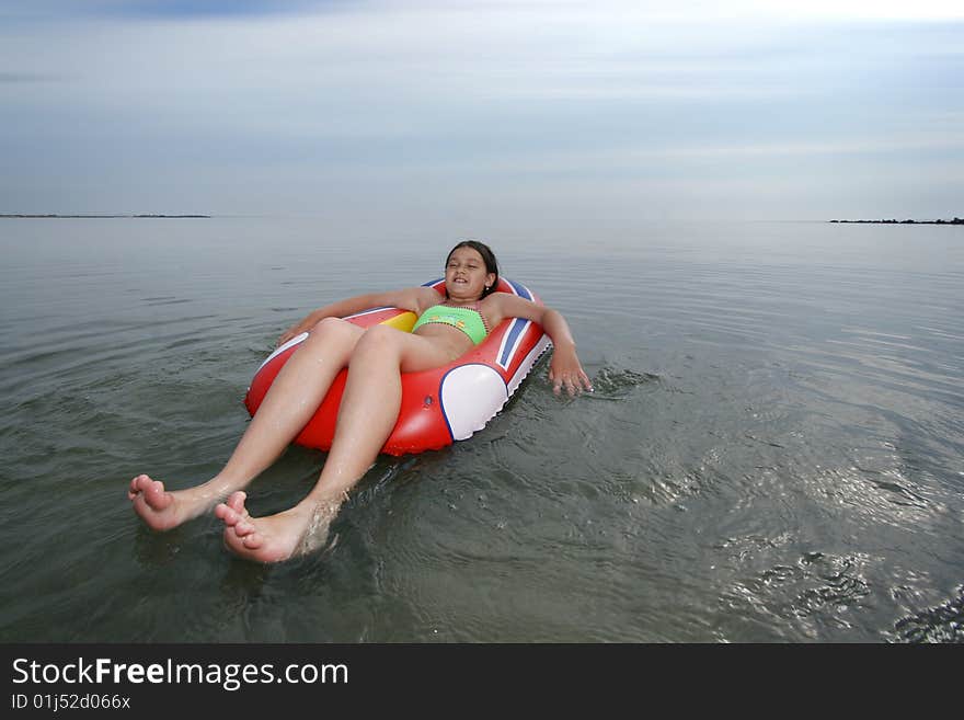 Little girl sitting on inflatable boat on sea. Little girl sitting on inflatable boat on sea