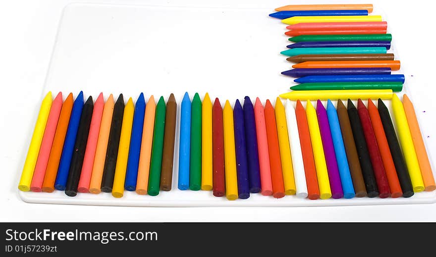 Many wax pencils on a white plastic board