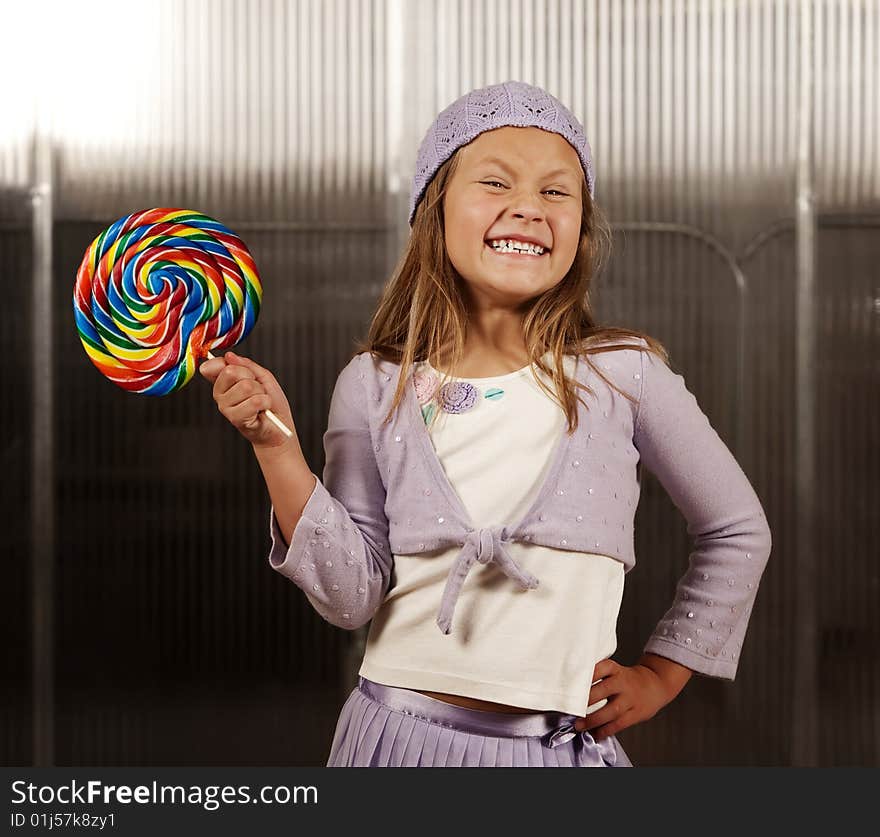 Cute young girl with lollipop and knit cap