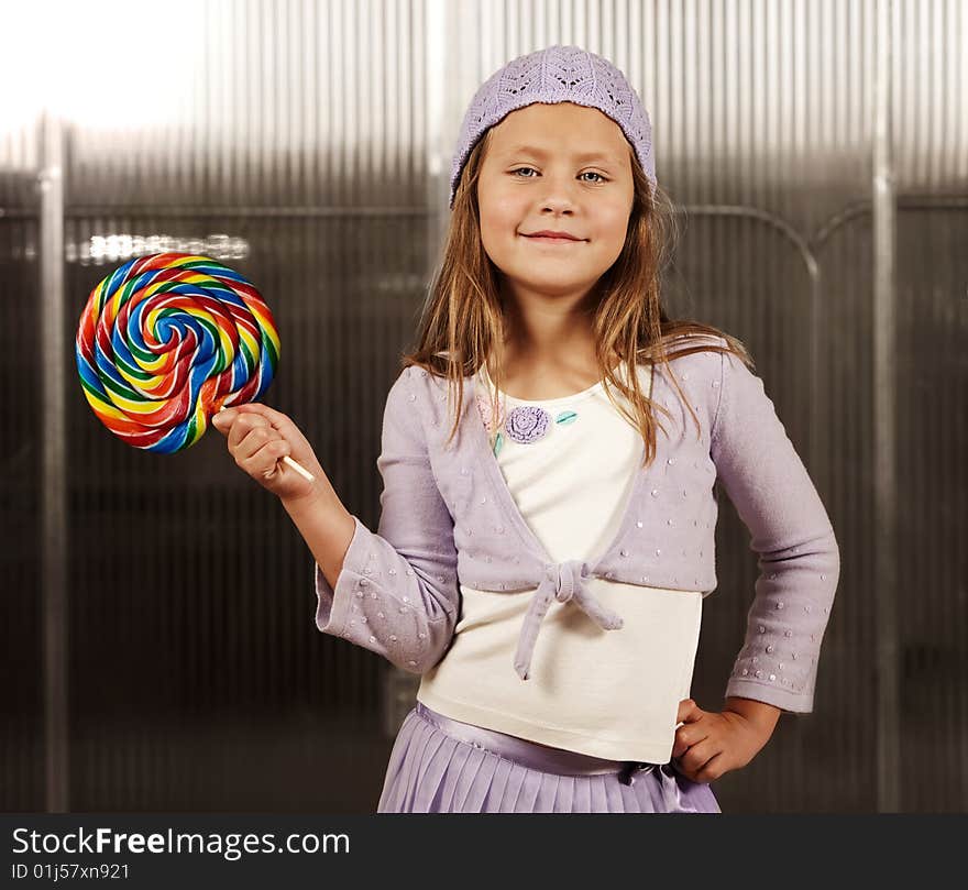 Cute young girl with lollipop and knit cap