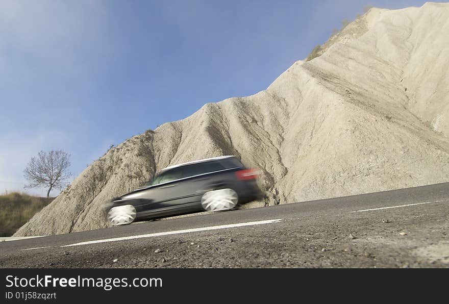 Black car moving in a arid landscape; Spain