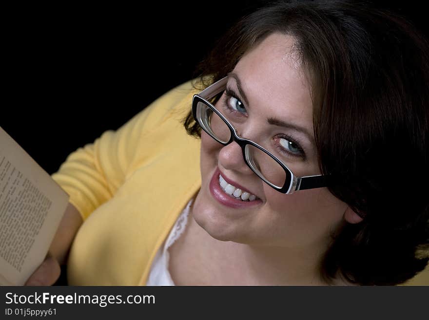 Woman wearing glasses and reading a book.